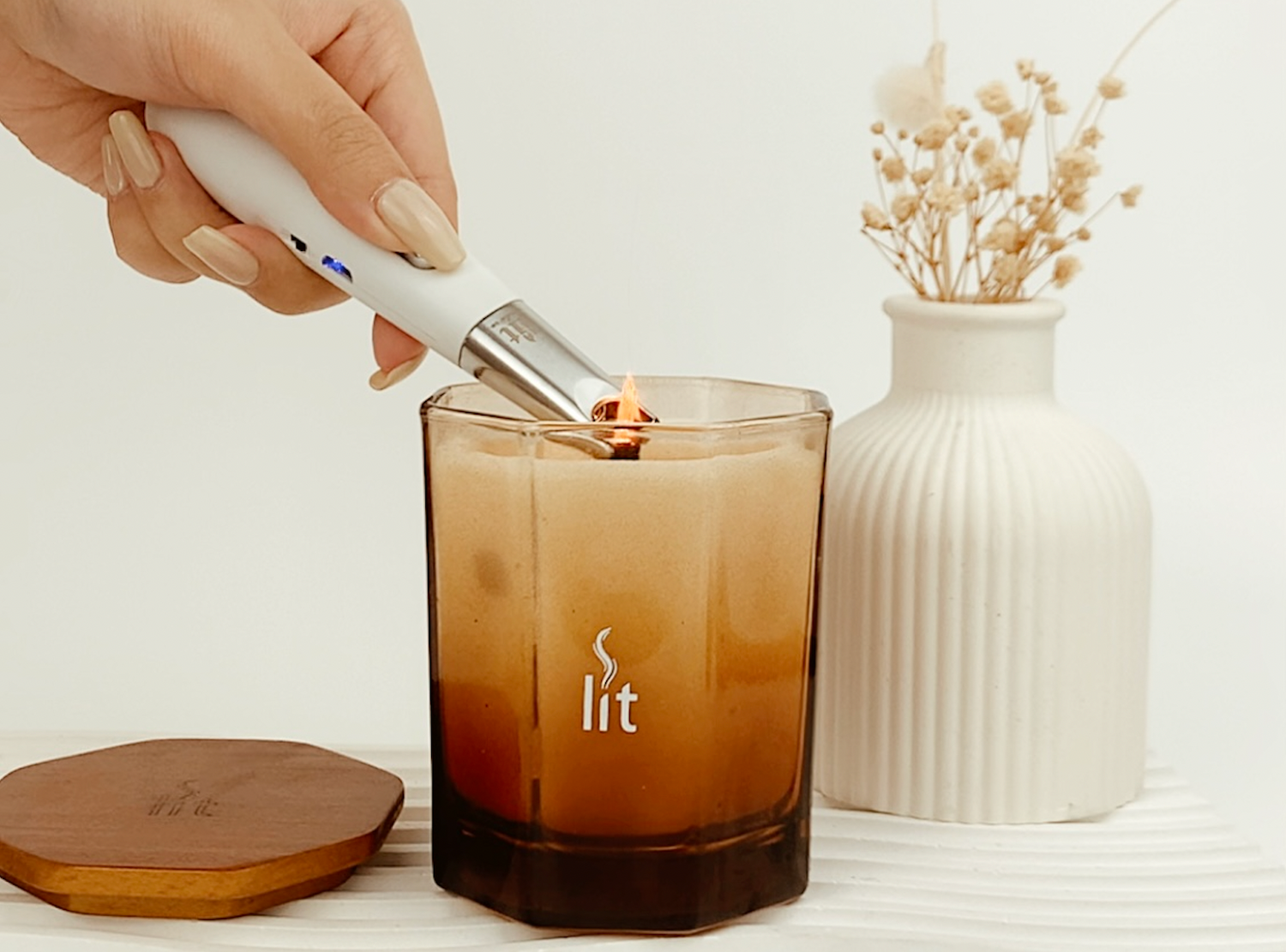 A lit 5oz scented soy candle being lit using an electric lighter